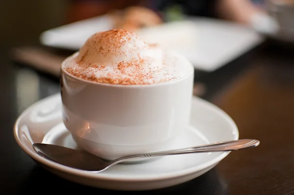 Um copo de cappuccino com espuma de leite e canela — Fotografia de Stock