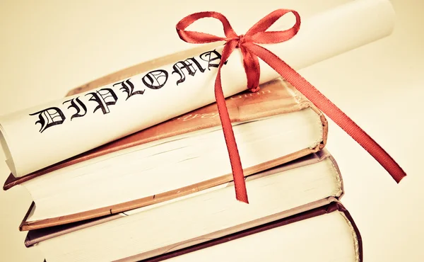 Diplom s červenou stužku a knihy — Stock fotografie