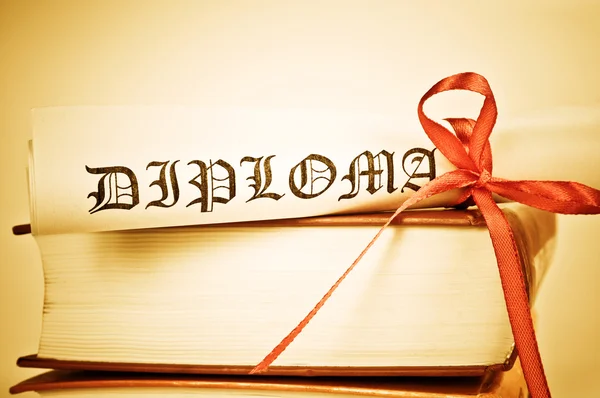 Diploma with red ribbon and books — Stock Photo, Image