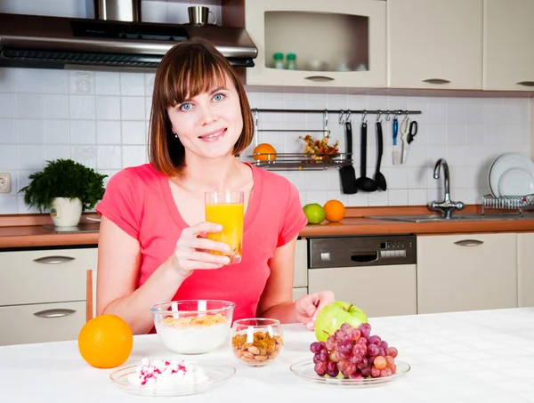 Jovem mulher bebendo suco de laranja em casa — Fotografia de Stock