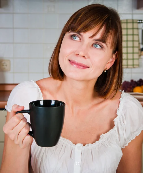 Junge Frau genießt eine Tasse Kaffee in ihrem Haus. — Stockfoto