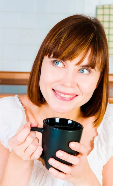 Jonge vrouw, genieten van een kopje koffie in haar huis. — Stockfoto