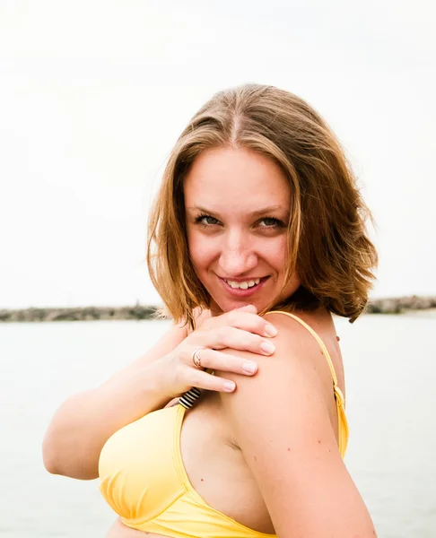 Fashion shot of a beautiful woman at the beach — Stock Photo, Image