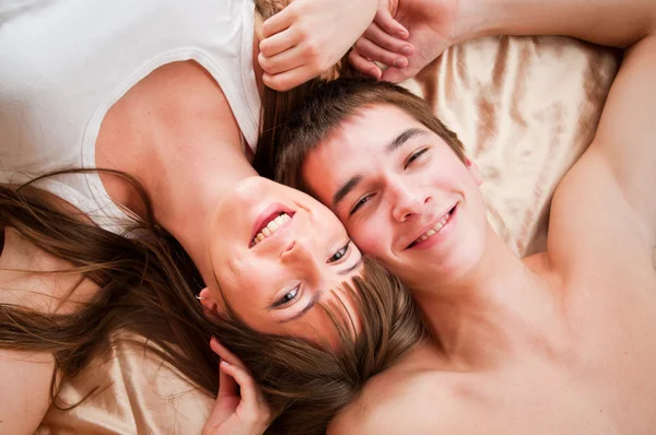 Fiatal, boldog pár az ágyban Stock Fotó