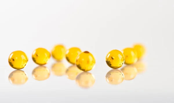 Yellow capsules isolated on white — Stock Photo, Image