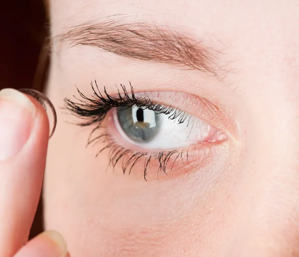 Fechar a inserção de uma lente de contacto no olho feminino — Fotografia de Stock