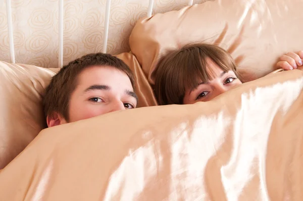 Unga par i en säng — Stockfoto