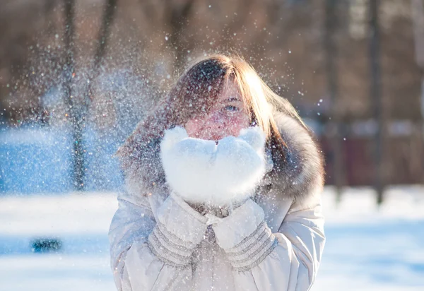 Mooie vrouw waait in de sneeuw — Stockfoto