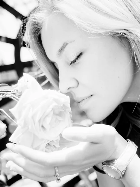 Mujer joven y bonita oliendo una rosa — Foto de Stock