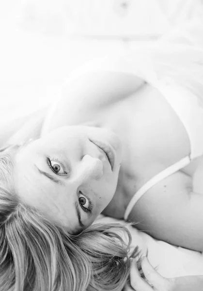 Seksi sarışın bir kadın iç çamaşırı yatakta yatıyordu. — Stok fotoğraf