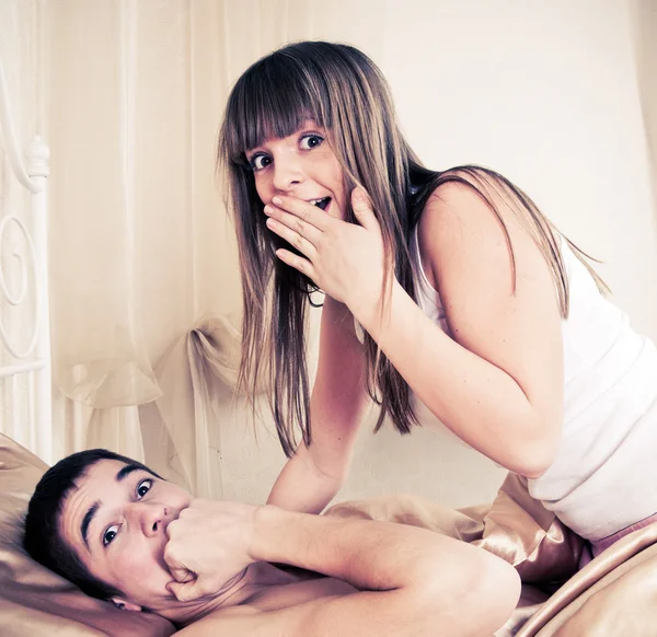 Surprised sex couple lying in bed — Stock Photo, Image