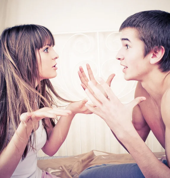 Portrait of an angry couple shouting each other against white ba — Stock Photo, Image