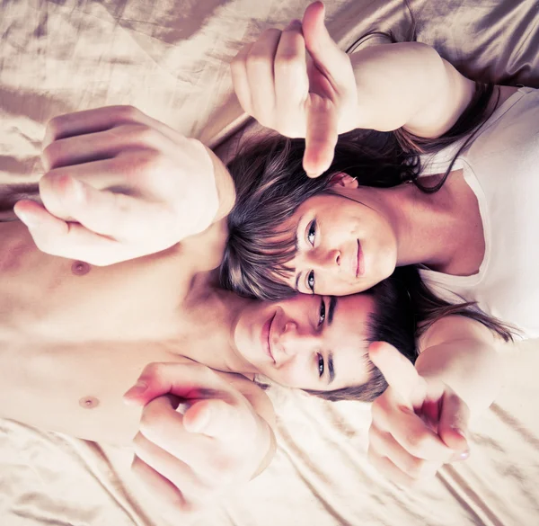 Foto ângulo largo de um jovem casal apontando para você — Fotografia de Stock