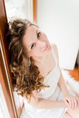 Kız pencere eşiğinde oturuyor