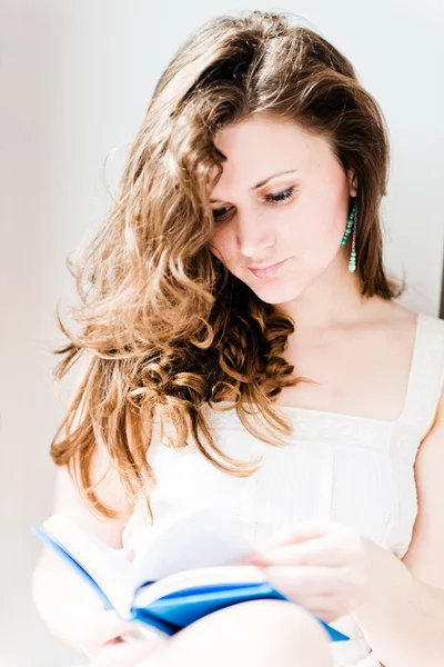 Mladý bělošský bruneta čtení knihy okna doma — Stock fotografie