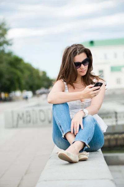 Outdoor Portret van een jonge vrouw met telefoon — Stockfoto