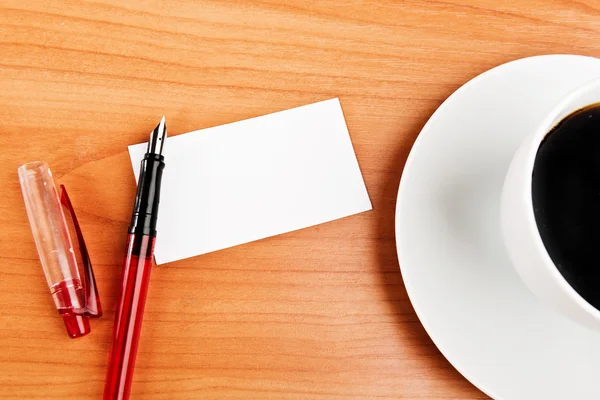 Tasse à café, morceau de papier et stylo sur la table en bois — Photo