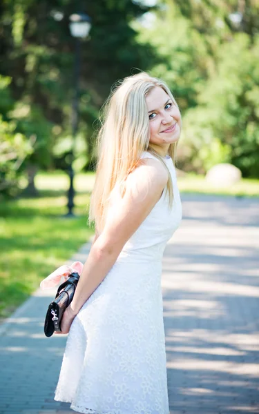 Красивая молодая блондинка в белом платье на открытом воздухе — стоковое фото
