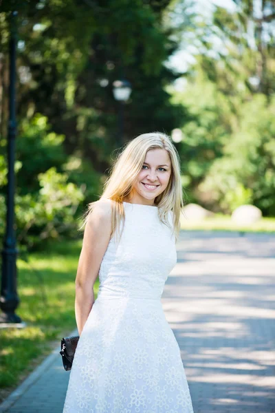 Mulher loira jovem bonita em um vestido branco ao ar livre — Fotografia de Stock