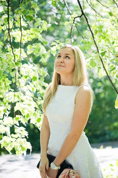 Vacker ung blond kvinna i en vit klänning utomhus — Stockfoto