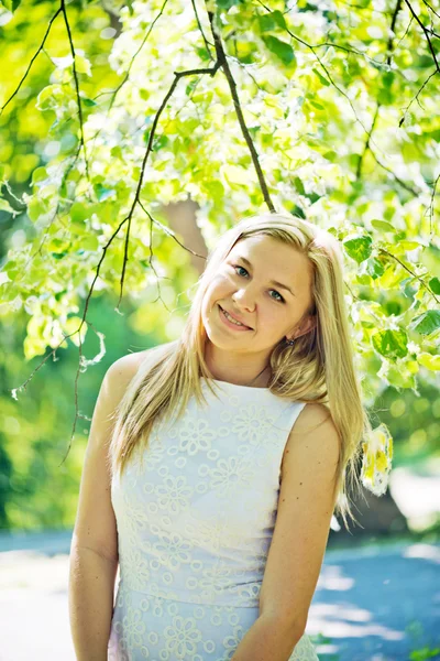 Beautiful young blond woman in a white dress outdoors — Stock Photo, Image