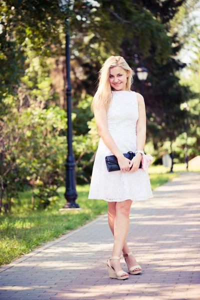 Mulher loira jovem bonita em um vestido branco ao ar livre — Fotografia de Stock