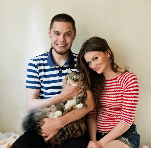 Счастливая молодая пара с кошкой — стоковое фото