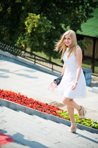 Beautiful blond woman walking upstairs outdoors — Stock Photo, Image