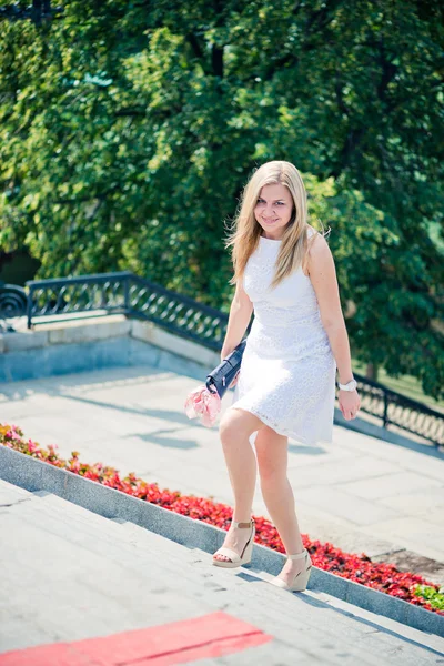 Beautiful blond woman walking upstairs outdoors — Stock Photo, Image