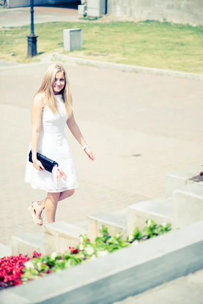 Beautiful blond woman walking upstairs outdoors — Stock Photo, Image