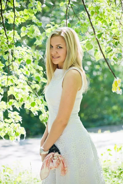 Mulher loira jovem bonita em um vestido branco ao ar livre — Fotografia de Stock