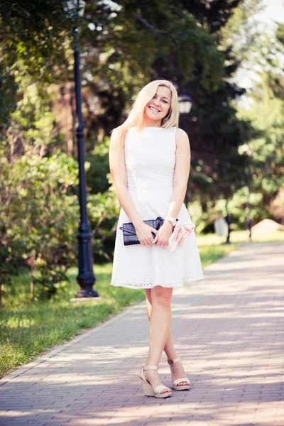 Mulher loira jovem bonita em um vestido branco ao ar livre — Fotografia de Stock