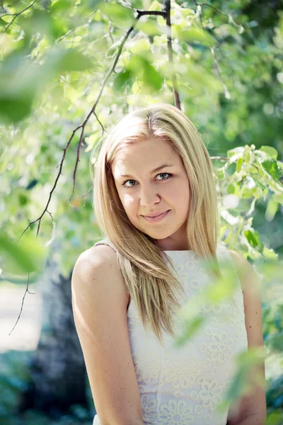 Beautiful young blond woman in a white dress outdoors Royalty Free Stock Images