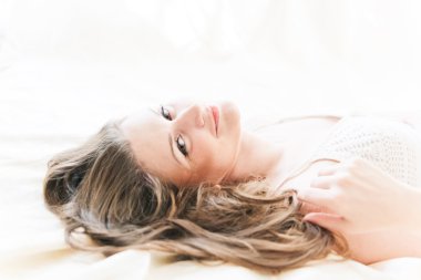 kahverengi saçlı kadın onun yorgan yatak odasında yatan