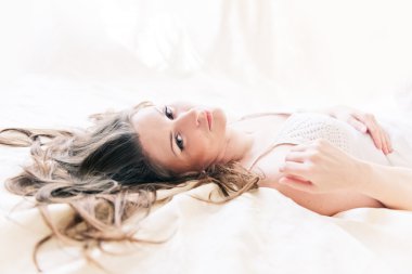 kahverengi saçlı kadın onun yorgan yatak odasında yatan