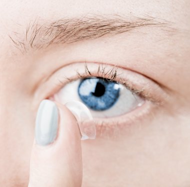 Close up of inserting a contact lens in female eye clipart