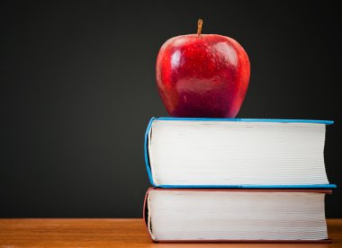 Kırmızı elma ve temiz blackboard ile kitap yığını