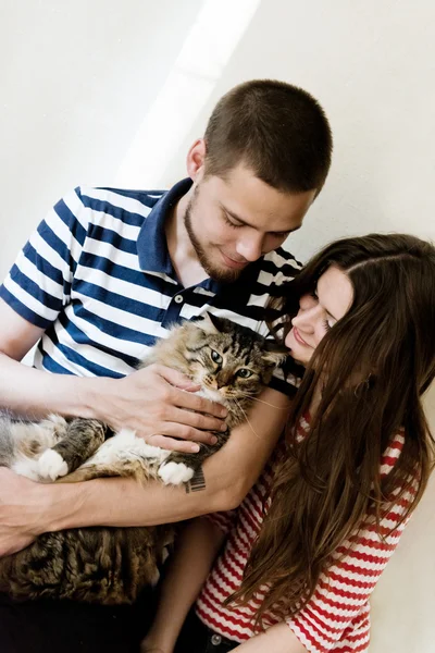 Gelukkige jonge paar thuis met hun kat — Stockfoto