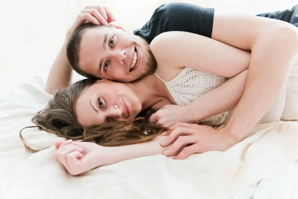 可爱的情侣拥抱在他们家里的床上 — 图库照片