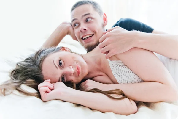 Adorável casal abraçando em sua cama em casa — Fotografia de Stock