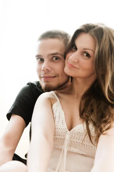 Lovely couple hugging on their bed at home — Stock Photo, Image