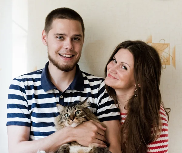 Gelukkige jonge paar thuis met hun kat — Stockfoto