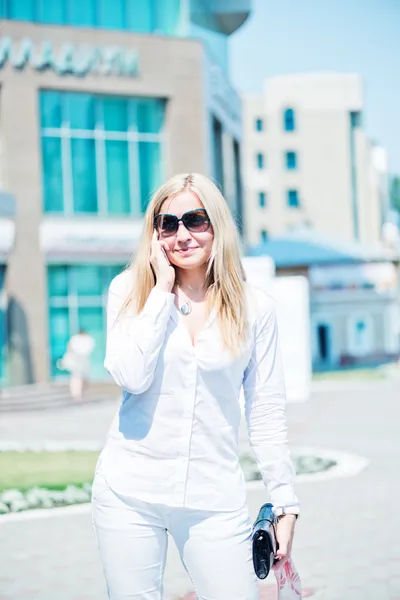 Schöne junge blonde Frau telefoniert im Freien — Stockfoto