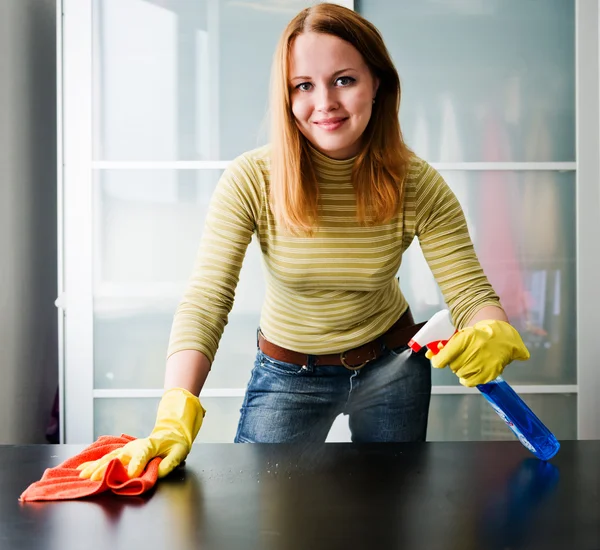 Glückliches Mädchen putzt Tisch mit Möbelpolitur zu Hause — Stockfoto