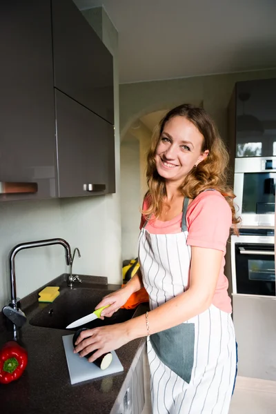 Mulher feliz cortando berinjela — Fotografia de Stock