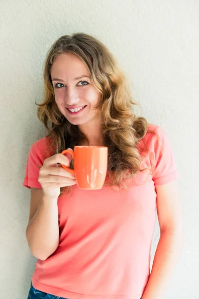 Schöne und lächelnde Frau mit einer Tasse Kaffee — Stockfoto