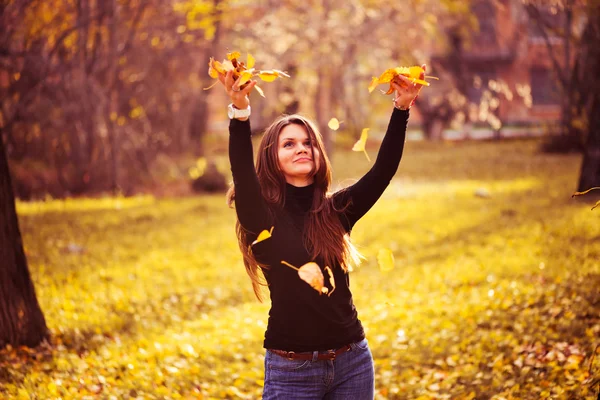 Young woman throwing leaves woman in the forest — Stock Photo, Image