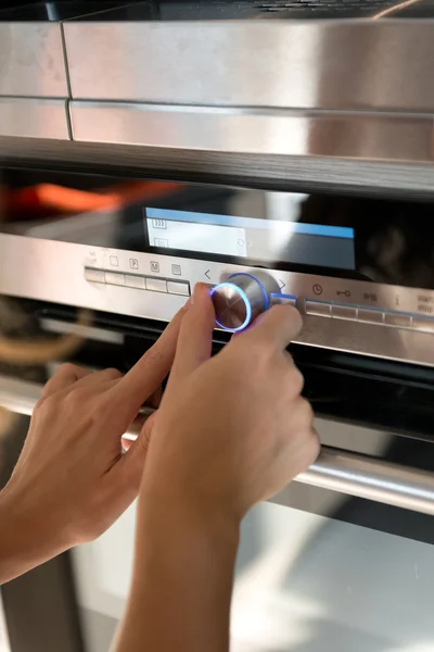 Mano moviendo la perilla del temporizador en el horno — Foto de Stock