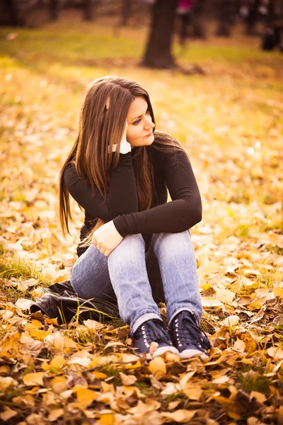 Beautiful thoughtful girl in autumn park — Stock Photo, Image