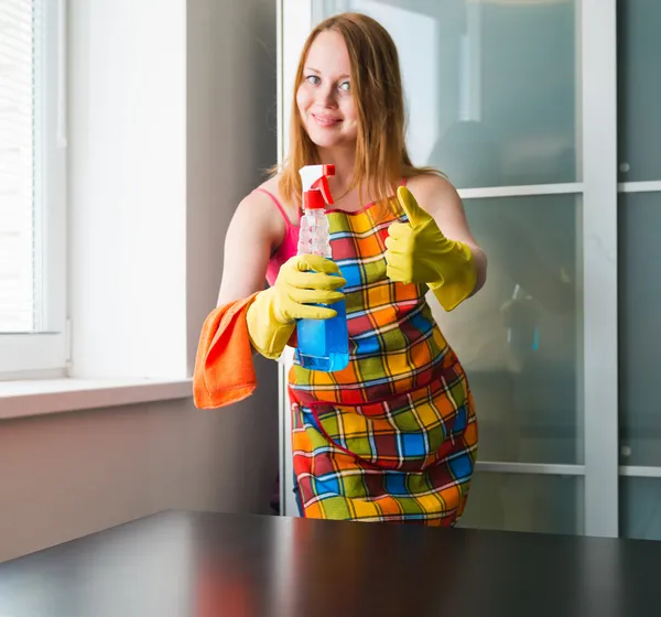 Happy girl cleaning table with furniture polish at home — Stock Photo, Image